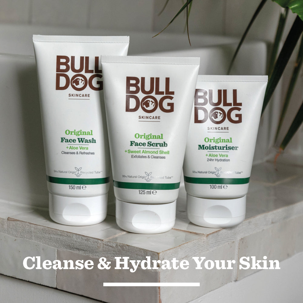 The Bulldog Skincare Original Moisturiser sits on a bathroom counter with green plants in the background. Text below reads: Cleanse & Hydrate Your Skin.