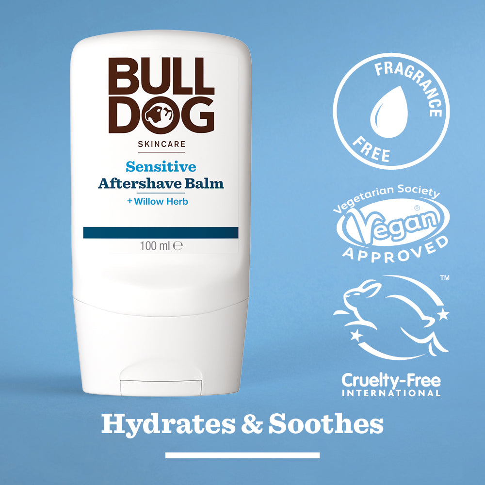 The Bulldog Sensitive Aftershave Balm, in a white bottle for sensitive skin, sits on a blue background with icons for Fragrance Free, Vegan Approved, and Cruelty-Free. Text reads: Hydrates & Soothes with natural origin ingredients.