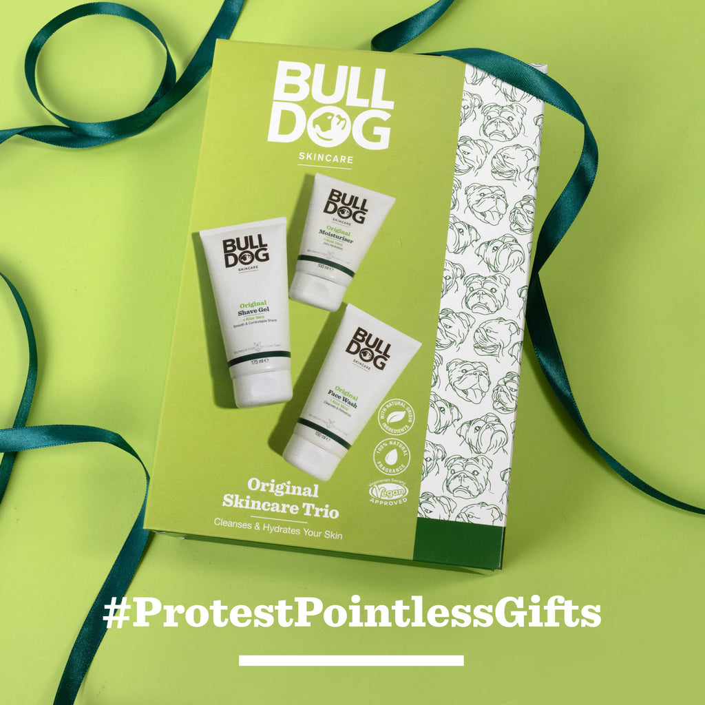 The Original Skincare Trio gift set is displayed on a green background with teal ribbon accents, and the hashtag #ProtestPointlessGifts appears in bold white text at the bottom.