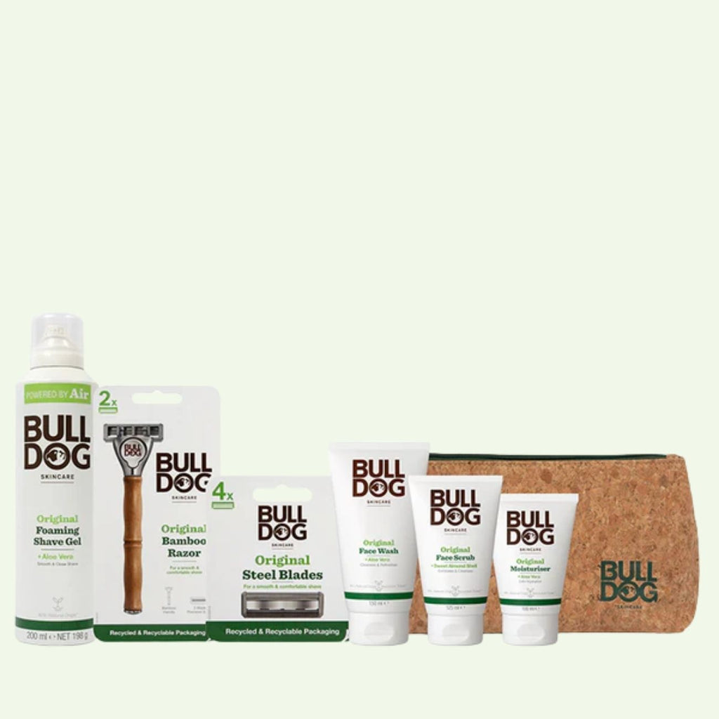 The Original Mens Grooming Bundle includes Bulldog Skincare essentials—foaming shave gel, bamboo razor with steel blades, face wash, scrub, moisturizer, and a brown toiletry bag with the Bulldog logo—displayed on a light background.